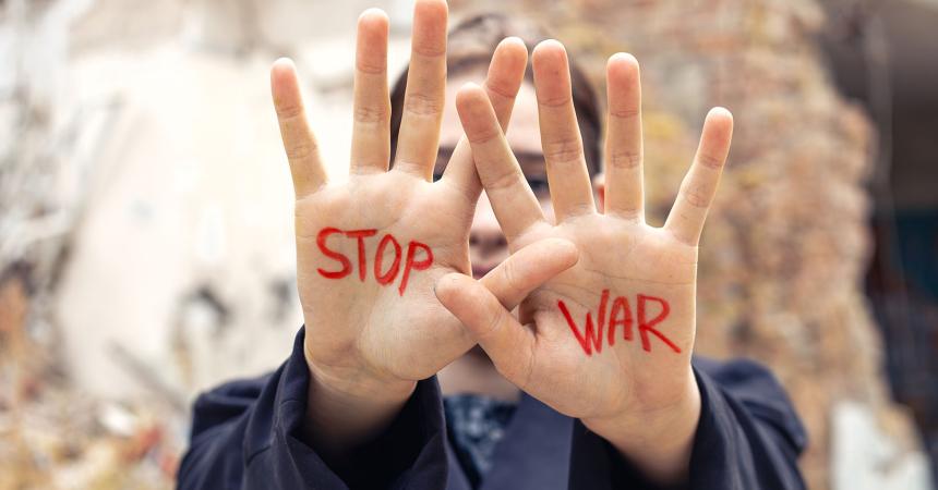Woman's hands raised with slogan written in red Stop War